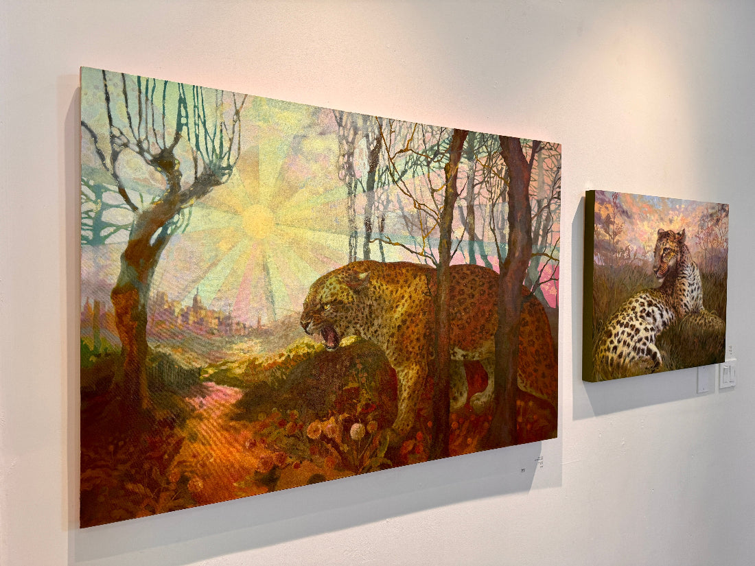 Two paintings of leopards in a forest setting on a wall.