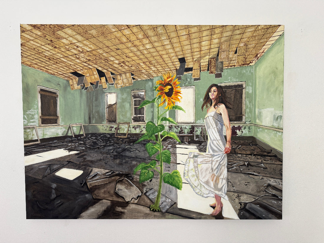 Woman in a white dress standing in a dilapidated room with a large sunflower.