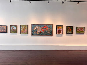 Art gallery with colorful paintings on a white wall