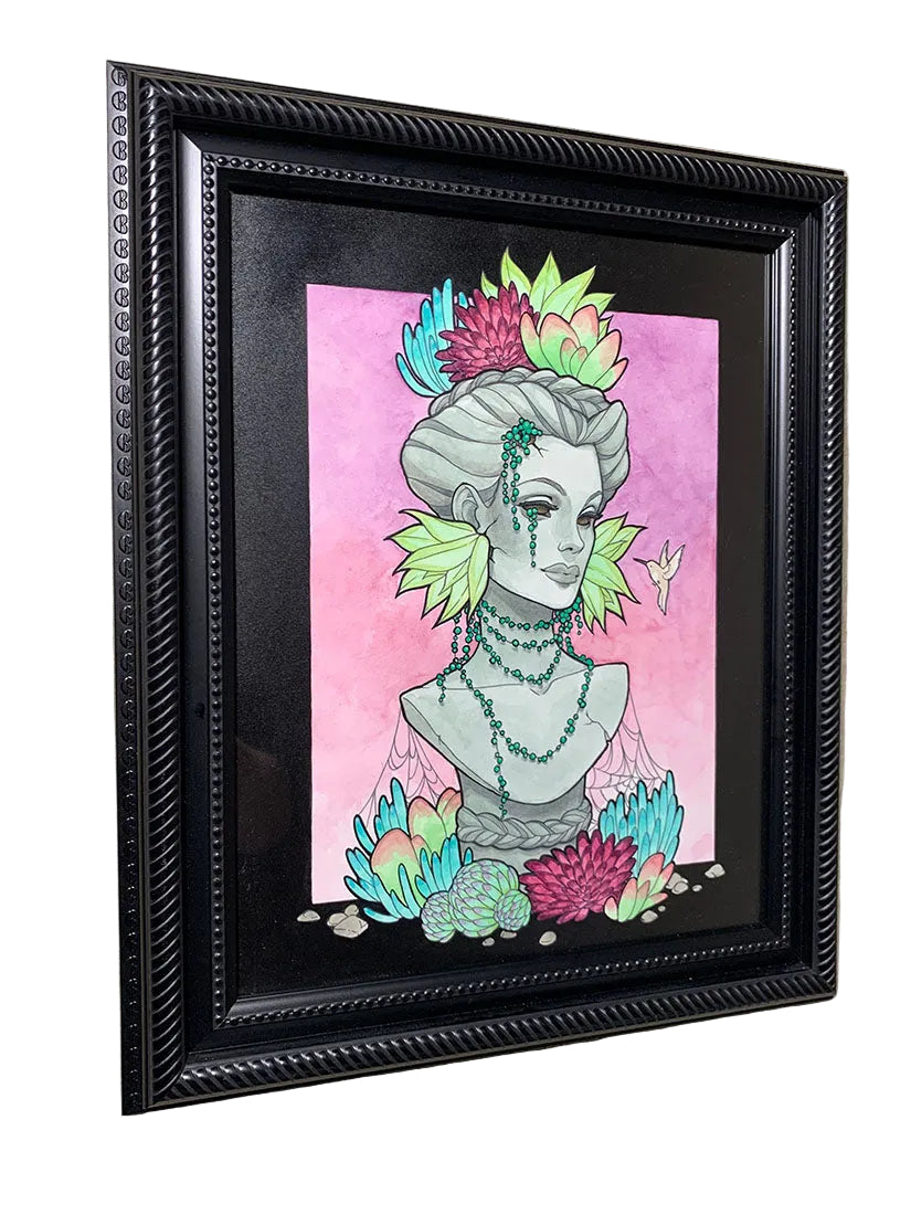 Framed artwork of a stylized bust with colorful elements on a pink background