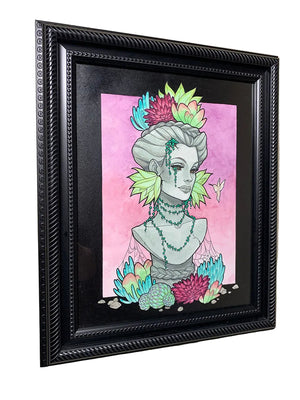 Framed artwork of a stylized bust with colorful elements on a pink background