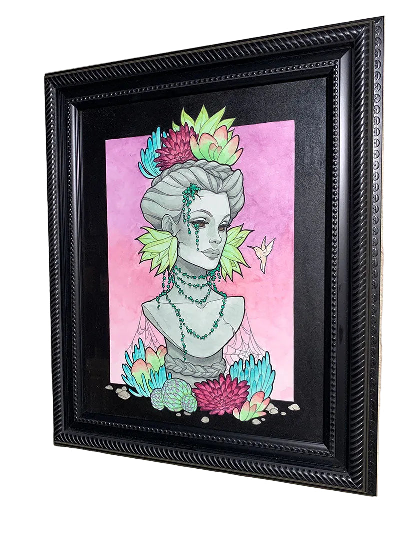 Framed artwork of a stylized bust with floral elements on a pink background