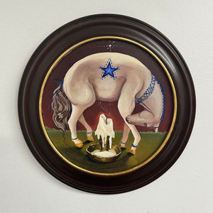 Framed artwork of a horse with a star on its back, standing over a small figure by a well.