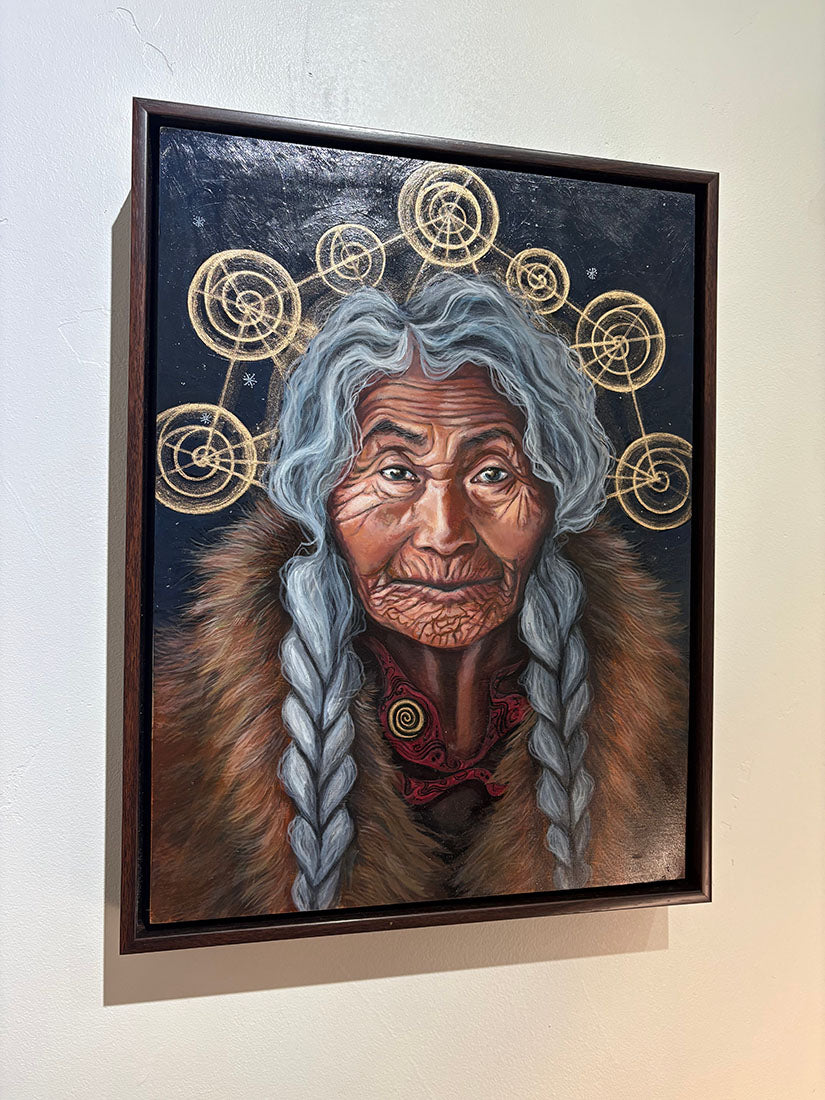 Framed artwork of an elderly person with braided hair and fur, against a starry sky background.
