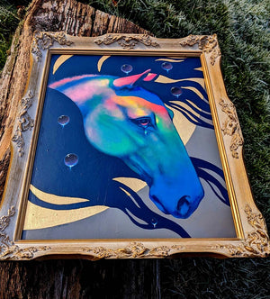 Colorful horse painting in a gold frame on a natural background