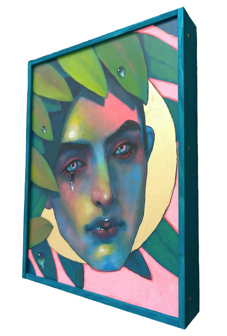 Colorful abstract portrait in a teal frame on a wooden surface
