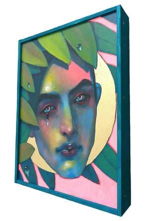 Colorful abstract portrait in a teal frame on a wooden surface
