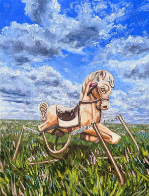 Toy horse on a grassy field with a blue sky