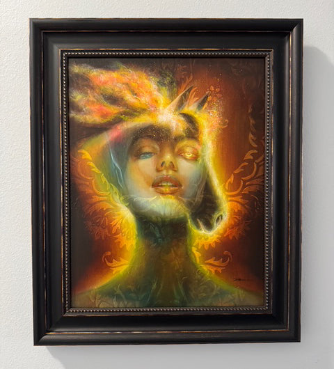 Framed artwork of a stylized face with vibrant colors on a white wall