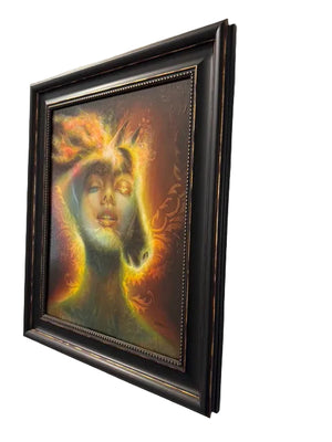 Framed artwork of a stylized face with abstract elements on a white wall