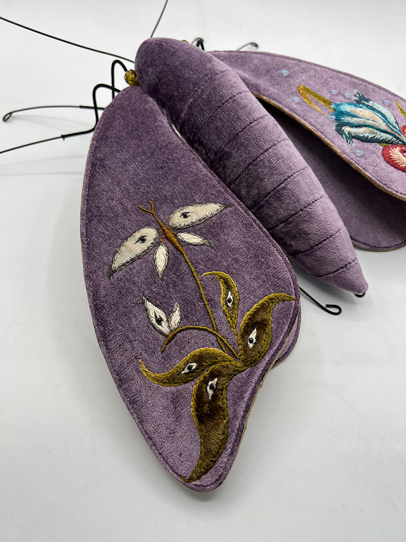 Decorative butterfly with embroidered wings on a white background