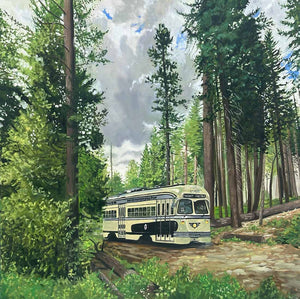 Vintage trolley in a forest setting with tall trees and a clear sky.