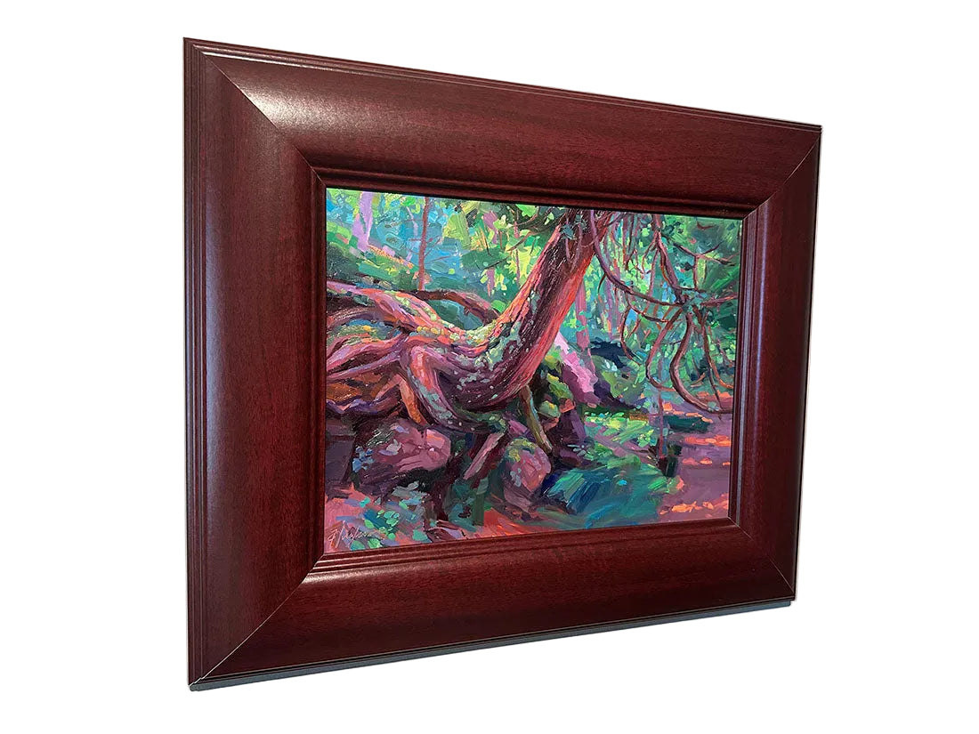 Framed painting of a colorful forest scene on a beige wall