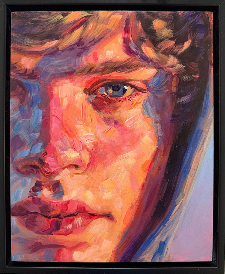 A framed portrait painting of a young man's face, rendered in expressive, colorful brushstrokes with warm skin tones, blue hair, and purple shadows, mounted on a textured off-white wall.