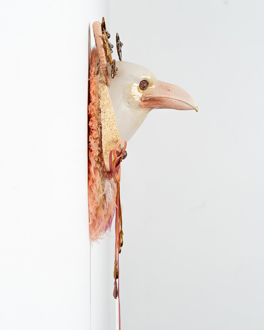Decorative bird head with feathers and gold accents on a white background