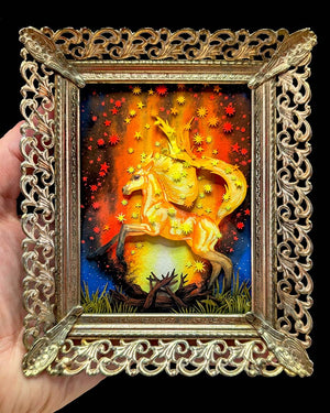 Decorative gold frame holding a painting of a unicorn with a fiery background.