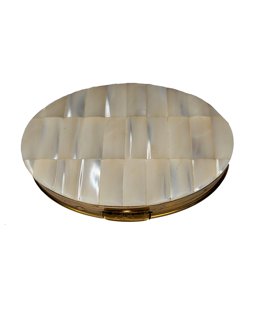 Round decorative item with a shell-like pattern on a white background