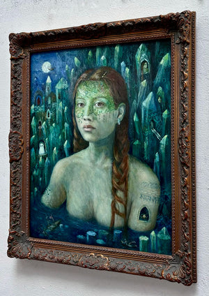 Framed artwork of a woman with tattoos and a fantasy landscape.