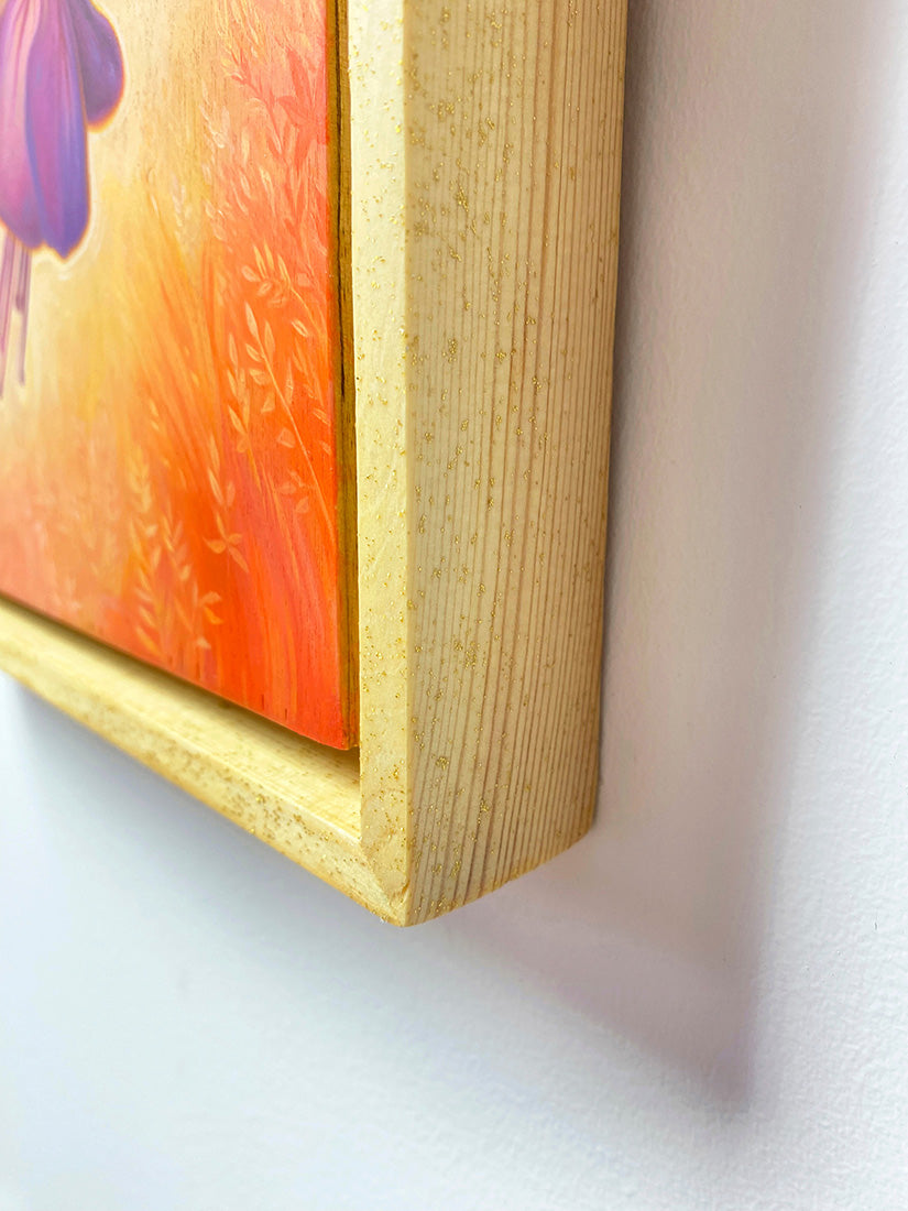 Close-up of a colorful painting with a wooden frame on a light background