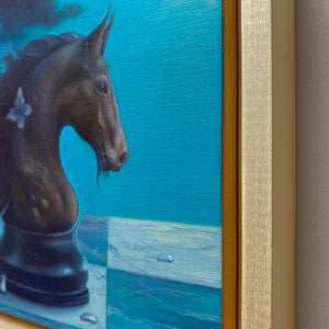 Close-up of a painting of a horse's head with a blue background and gold frame.