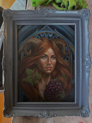 Framed artwork of a woman with long red hair and a decorative frame.