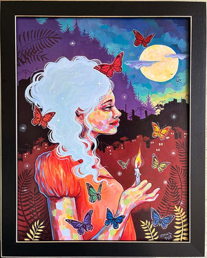 Framed artwork of a woman with butterflies and a candle against a colorful night sky.